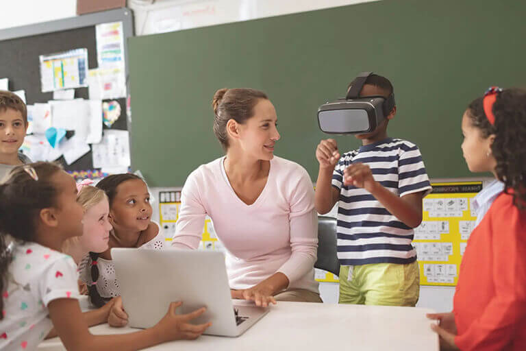 front view of schoolboy using virtual reality headset at school in classroom at school