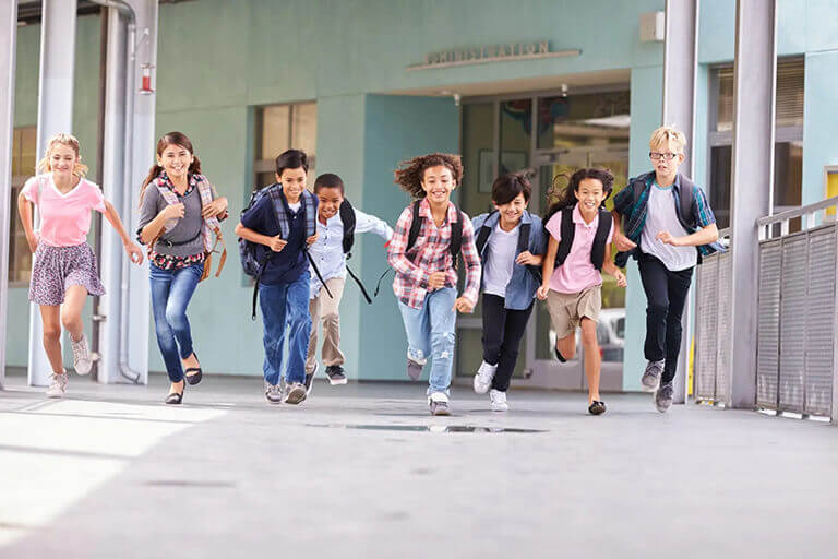 group of elementary school kids running in a school corridor 1